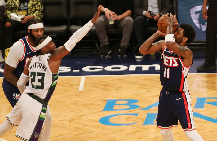 Brooklyn Nets guard Kyrie Irving (11) takes a shot against Milwaukee Bucks guard Wesley Matthews (23) during the second half at Barclays Center.
